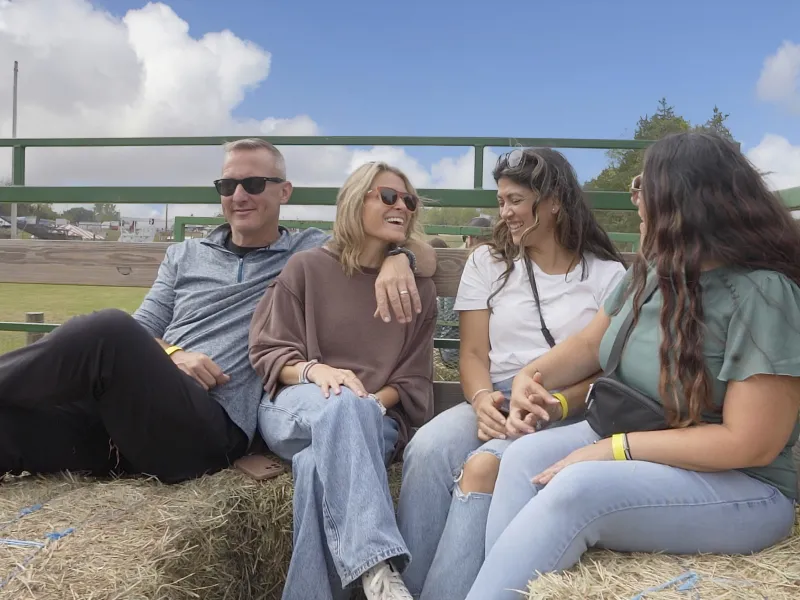 Four adults taking a hayride.