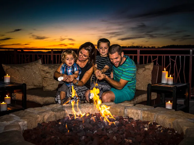 Family roasting marshmallows on the Fire and Water Terrace at Grand Cascades Lodge.