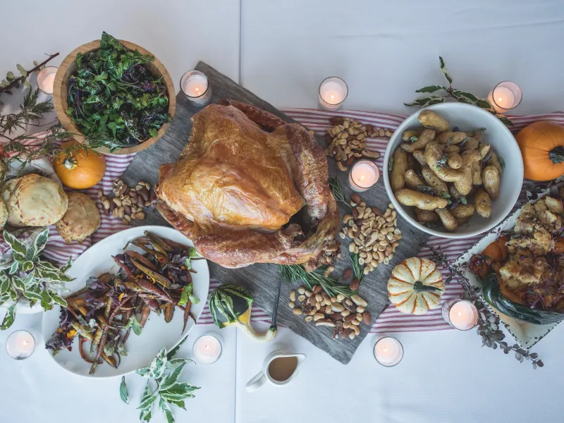 Table with spread of Thanksgiving food and candles 