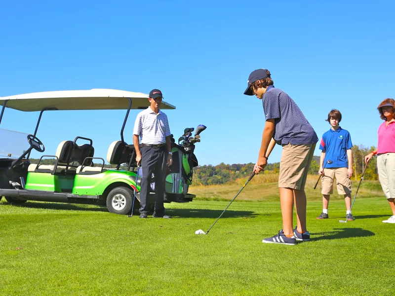 Family playing golf on a course at Crystal Springs Resort