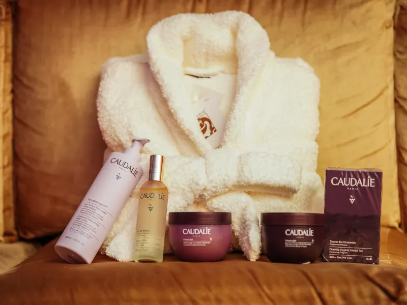 Caudalie products in front of white robe.