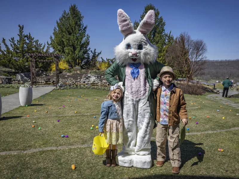 Two children standing with Easter bunny.