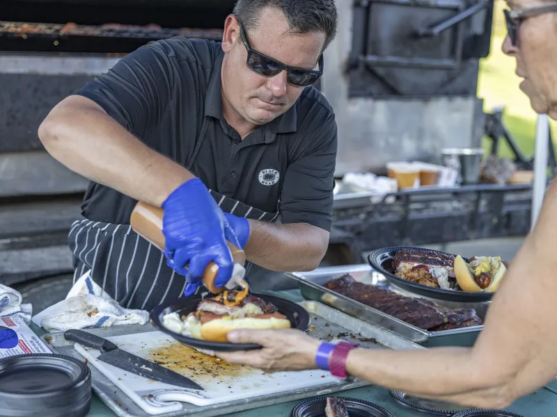 Cook plating food at Black Bear Bourbon and BBQ.