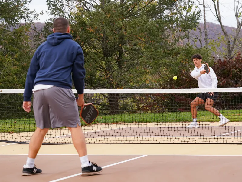 Two boys playing pickleball.