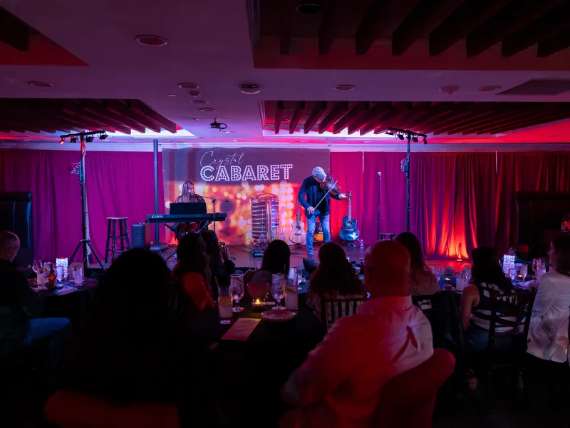 Man on Crystal Cabaret stage playing a violin.